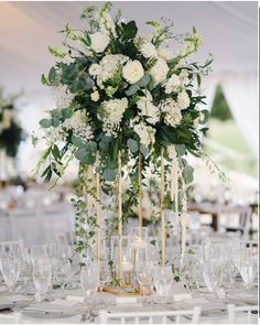 an elegant centerpiece with white flowers and greenery