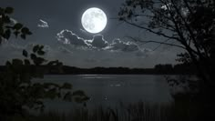 the full moon is setting over a lake