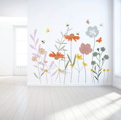 an empty room with flowers and butterflies painted on the wall