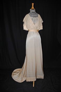 "SILK SATIN WEDDING DRESS WITH BATTENBURG LACE, TRAINED, 1920s This is an attractive Victorian wedding gown dating from 1920s is a gown that a  mid to upper class dress that a woman would wear. A regal off white gown that was deaccession from the Strong  Museum in Rochester  New York. The gown still retains original Museum ID catalog tags. The bodice is decorated with battenburg lace on front and back drop. With a high neck collar decorated with faux pearls and white beads.  Both neck collar and Vintage Evening Gown With Historical Design, Vintage Floor-length Evening Dress For Vintage Events, Fitted Wedding Dress With Historical Design, Wedding Evening Dress With Bias Cut, Vintage Ceremony Gown With Fitted Bodice, Vintage Gown With Fitted Bodice For Ceremony, Elegant Vintage Wedding Dress With Historical Design, Fitted Vintage Wedding Dress With Historical Design, Vintage Floor-length Wedding Gown