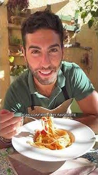 a man sitting at a table eating spaghetti