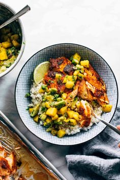 a bowl filled with rice and chicken next to another bowl full of food on a table