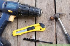 a hammer, screwdriver and other tools sitting on a wooden table next to each other