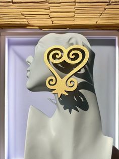 a mannequin's head with a pair of earrings in the shape of a heart