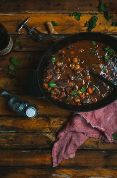 a pot filled with stew on top of a wooden table