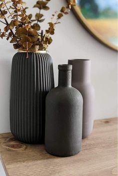 two vases sitting on top of a wooden table