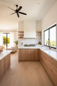 an open kitchen with wooden cabinets and white counter tops, along with a ceiling fan