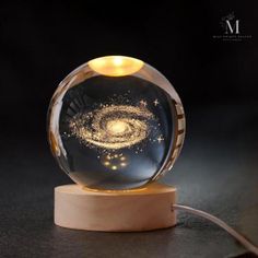 an image of a glass ball with a light inside it on top of a wooden stand