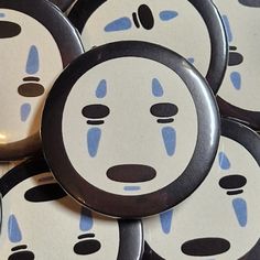 several buttons with faces drawn on them sitting next to each other in the same pattern