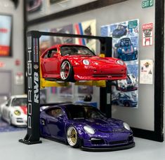 two toy cars are stacked on top of each other in front of a display case