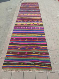 a multicolored striped rug on the sidewalk