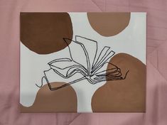 a book is sitting on top of a pink sheet with brown circles in the background