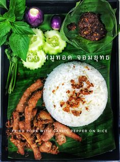 a plate with rice, meats and vegetables on it is shown in thai writing