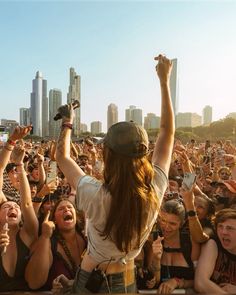 a group of people at a concert with their hands in the air and one person holding a microphone