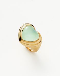 Jelly Heart Gemstone Ring | 18ct Gold Plated/Aqua Chalcedony blue/gold. Share the Love. The Chubby Jelly Heart Gemstone Ring is Set with a Dyed Aqua Chalcedony Cabochon Stone – Known for Bringing Harmony – Surrounded by Signature Ridge Detailing on a Domed Band. Wear Solo or Stack with Other Chunky Pieces. This Piece Contains a Semi-Precious Gemstone that is Natural, Meaning Each Stone is Completely Unique. There May be Variations in the Patterns, Colour Hues and Size Because of This. Metal: 18Ct Recycled Gold Plated on Brass Gemstone: Aqua Chalcedony Dimensions: 20mm X 17mm Stone Height: 7mm Weight: 9. 5g Product Code: Msg-G-R1-Aqc Please Note: Our Gemstones are Naturally Sourced and May Vary in Colour. Gold Heart-shaped Gemstone Jewelry, Heart Cabochon Ring, Handmade Gold Chalcedony Rings, Handmade Green Chalcedony Rings, Unique Cabochon Chalcedony Ring, Jelly Hearts, Purple Quartz, Leaf Bracelet, Chunky Rings