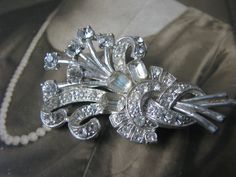 "An amazing Art Deco paste  and pot metal brooch. It is a very \"stylized\" design which resembles a floral bouquet. It measures 2 1/8'' x 1 1/8''. In beautiful condition with some wear to the finish and subtle fading to the stones, yet still very sparkly!" Antique Silver Wedding Brooches, Victorian Silver Wedding Brooches, Silver Art Deco Brooches For Wedding, Ornate White Brooches For Wedding, Silver Art Deco Wedding Brooches, Silver Art Deco Wedding Brooch, White Ornate Wedding Brooches, Ornate White Wedding Brooches, Victorian Brooch Pins For Wedding