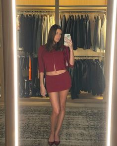 a woman taking a selfie in front of a closet