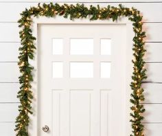 a white door decorated with christmas garland and lights