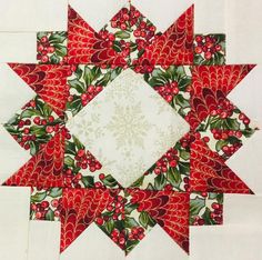 a red and white quilted star with holly decorations