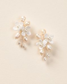 two pairs of pearl and crystal flower clip on earrings, one with white flowers in the middle