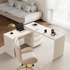 a white desk with a laptop on it in front of a couch and chair next to a window