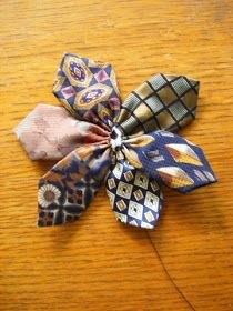 three different types of fabric flowers on a wooden table