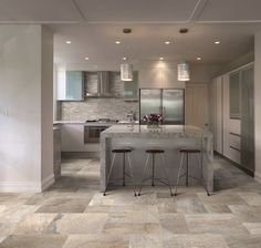 a kitchen with marble counter tops and stools next to an island in the middle