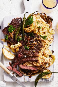 a white plate topped with steak and cauliflower