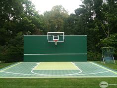 an outdoor basketball court in the middle of some trees