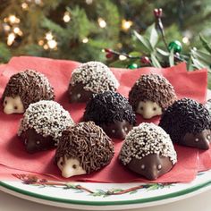 chocolate truffles with sprinkles on a plate near a christmas tree