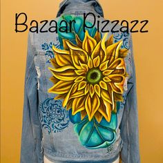 a denim jacket with a sunflower painted on it