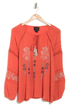 A beautifully embroidered tunic top features a keyhole tie neck and balloon sleeves for boho-chic style. 26" length (size M) Split neck with tassel ties Long raglan balloon sleeves with elastic cuffs Front keyhole Embroidered Inset ladder and lace trim Textured woven construction 100% rayon Hand wash, line dry Imported Model stats: 5'10" height, 32" bust, 25" waist, 36" hip. Model is wearing size M. Embroidered Tunic Top, Embroidered Tunic, Long Sleeve Tunic, Balloon Sleeves, Tie Neck, Boho Chic Fashion, Tunic Top, Lace Trim, Chic Style