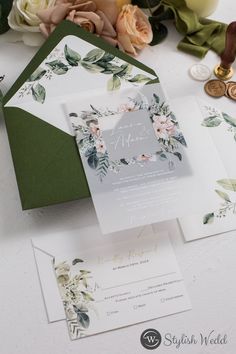 the wedding stationery is laid out on top of the table with flowers and coins