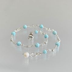 Genuine Caribbean aqua-blue larimar bracelet, wire-wrapped in sterling silver. This minimal and feminine bracelet features genuine, premium-quality larimar gemstones meticulously wire-wrapped onto double-strand segments of sterling silver chain. These pastel blue stones are micro-faceted and pair beautifully with silver for a delicate look.  A lobster claw clasp, accented with a small freshwater pearl finishes this bracelet. Dainty and subtle, this lovely bracelet is perfect by itself or layered with others.   This bracelet is enlarged to show details.  Details: *  length: please choose at check out genuine, faceted AAA Caribbean blue larimar (3.5 mm) freshwater pearl: approx 4 mm sterling silver chain and clasp  *  Choosing your length at checkout:  I recommend 1/2 inch larger than your a Elegant Blue Amazonite Bracelets, Elegant Blue Amazonite Bracelet, Elegant Turquoise Aquamarine Beaded Bracelets, Adjustable Larimar Round Bead Jewelry, Adjustable Blue Larimar Jewelry, Elegant Turquoise Larimar Bracelets, Adjustable Turquoise Larimar Beaded Bracelets, Turquoise Larimar Natural Stone Bracelets, Turquoise Larimar Bracelet