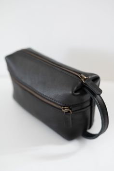 Natural grain leather toiletry bag, lined with cotton fabric. Wide-open interior for easy access to toiletries and other daily essentials. Featuring two zippered exterior pocket. Black Leather Travel Cosmetic Bag, Classic On-the-go Cosmetic Bag With Zipper, Black Leather Cosmetic Bag, Classic Black Cosmetic Bag For Everyday Use, Leather Travel Cosmetic Bag With Zipper Pocket, Leather Cosmetic Bag With Zipper Pocket For Travel, Leather Travel Cosmetic Bag With Zipper, Classic Soft Leather Travel Pouch, Black Leather Cosmetic Bag With Zipper