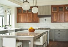 a large kitchen with wooden cabinets and marble counter tops, along with white stools