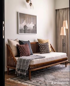 a living room with a futon and pillows on the floor next to a window