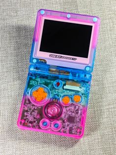 a pink and blue electronic device sitting on top of a table