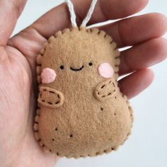 a hand holding a small felt animal ornament