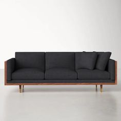 a black couch sitting on top of a white floor