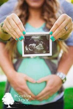 a pregnant woman holding an x - ray in her hands