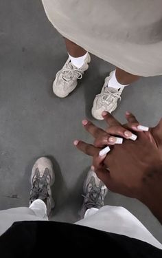 two people standing next to each other with their hands on top of one another's fingers