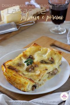 a white plate topped with lasagna casserole next to a glass of wine