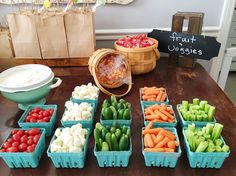 several trays of vegetables on a table with a sign that says fruit veggies