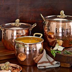 copper pots and pans are sitting on a table