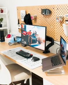 a laptop computer sitting on top of a wooden desk next to a monitor and keyboard