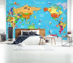 a bedroom with a blue wall and large map on the wall, it is decorated in bright colors