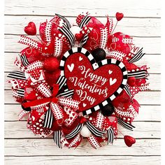 a valentine's day wreath with hearts and ribbons on a white wooden background that says happy valentine's day