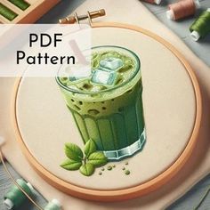 an embroidery pattern with a green drink on it