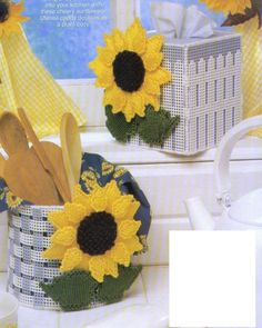 two crocheted sunflowers sitting in a basket next to each other on a counter